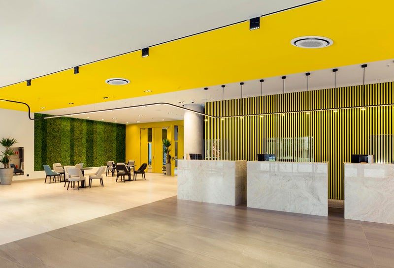 Interior of a hotel lobby with reception desks with transparent covid plexiglass lexan clear sneeze guards Interior of a hotel lobby with reception desks with transparent covid plexiglass lexan clear sneeze guards