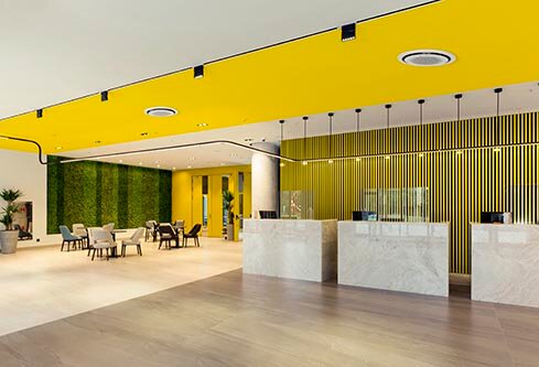 Interior of a hotel lobby with reception desks with transparent covid plexiglass lexan clear sneeze guards