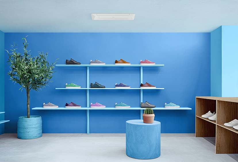 A modern shoe store with a wall shelf and shoe display in brown and white, decorated with plants and flowers.
