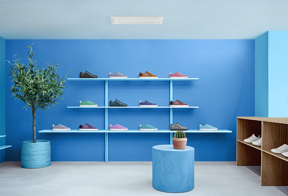 A modern shoe store with a wall shelf and shoe display in brown and white, decorated with plants and flowers.