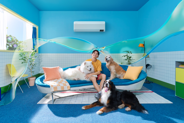 A man and 3 dogs on a couch cool off 43% faster with WindFree. Its fan is 15% bigger, the blades are 43% wider and the inlet is 18% wider, as indicated by arrow.